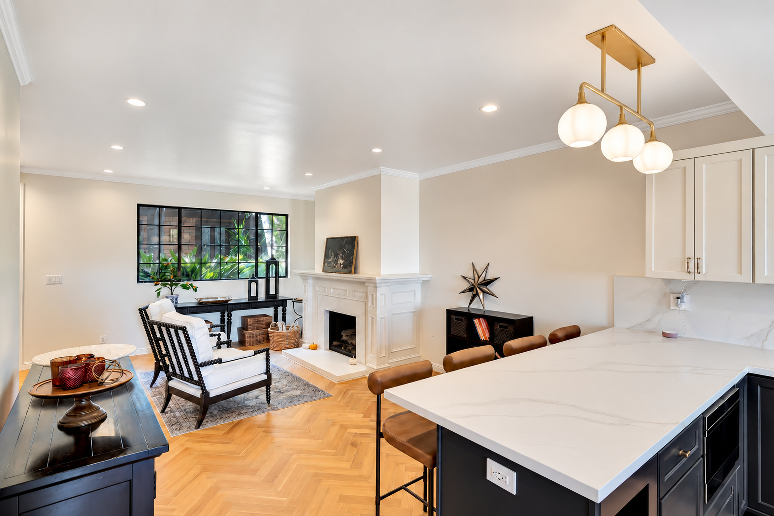 Open living room and kitchen with herringbone floors and fireplace